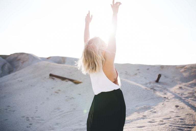 woman with arms lifted celebrating post traumatic growth